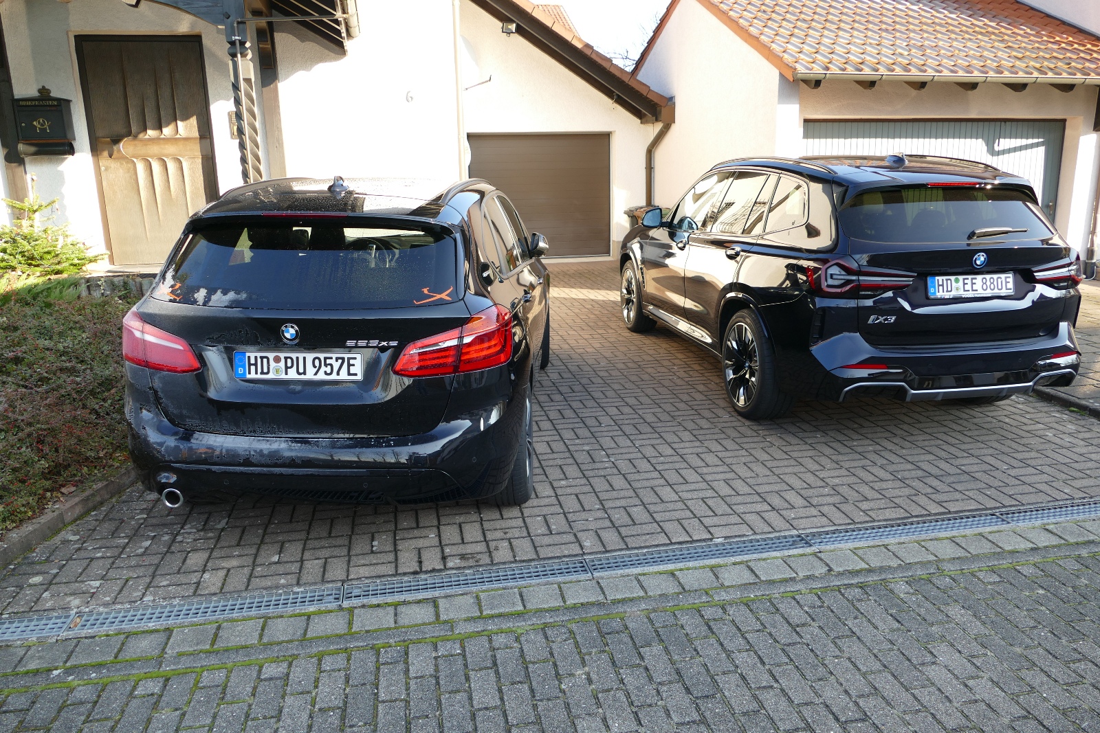 BMW Active Tourer neben BMW iX3 in der Einfahrt